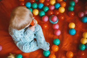 Work on Action Words with Balls Baby surrounded by colorful plastic balls