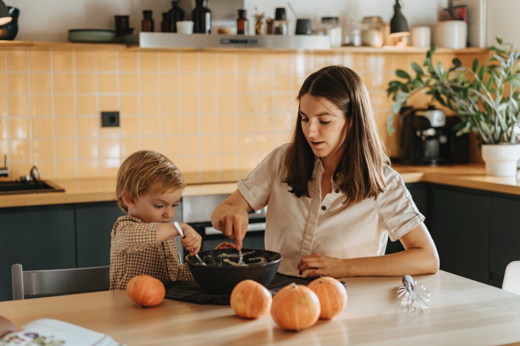 Child and parent preparing food in a kitchen