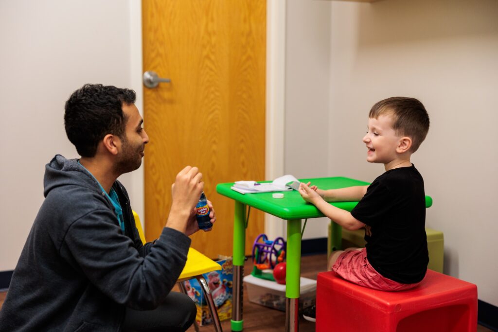 Therapist working with a boy at a table