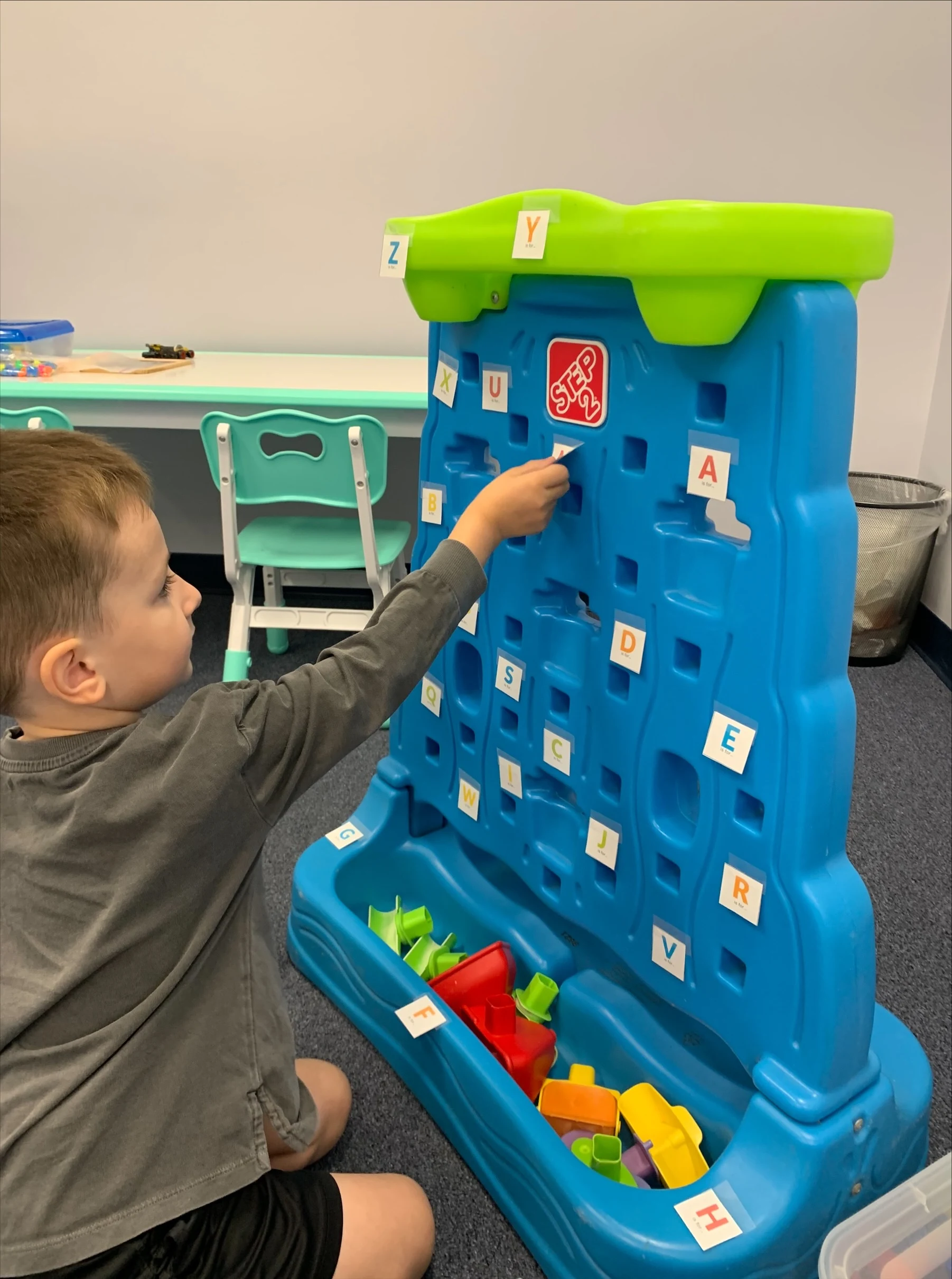 Child playing with a colorful pattern toy wall