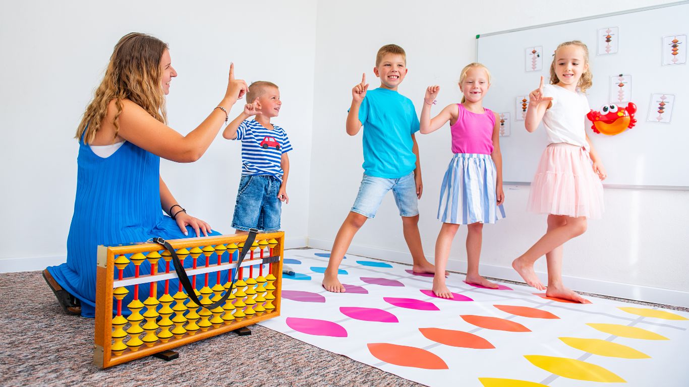 Therapist leading children in a movement activity on a floor mat