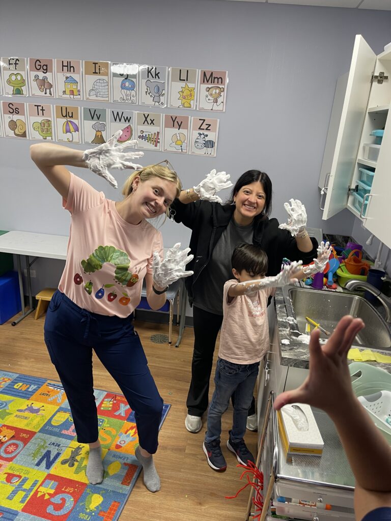 Therapist and child dancing in a playroom