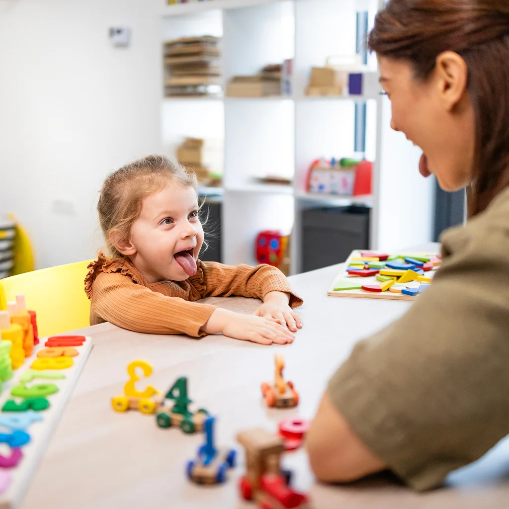 Young girl talking with a therapist at a play table